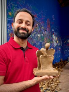 Ashik with his abstract modernist sculpture he made at the pottery workshop.