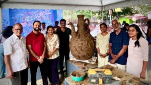 Some of the participants of the pottery workshop along with the community sculpture.